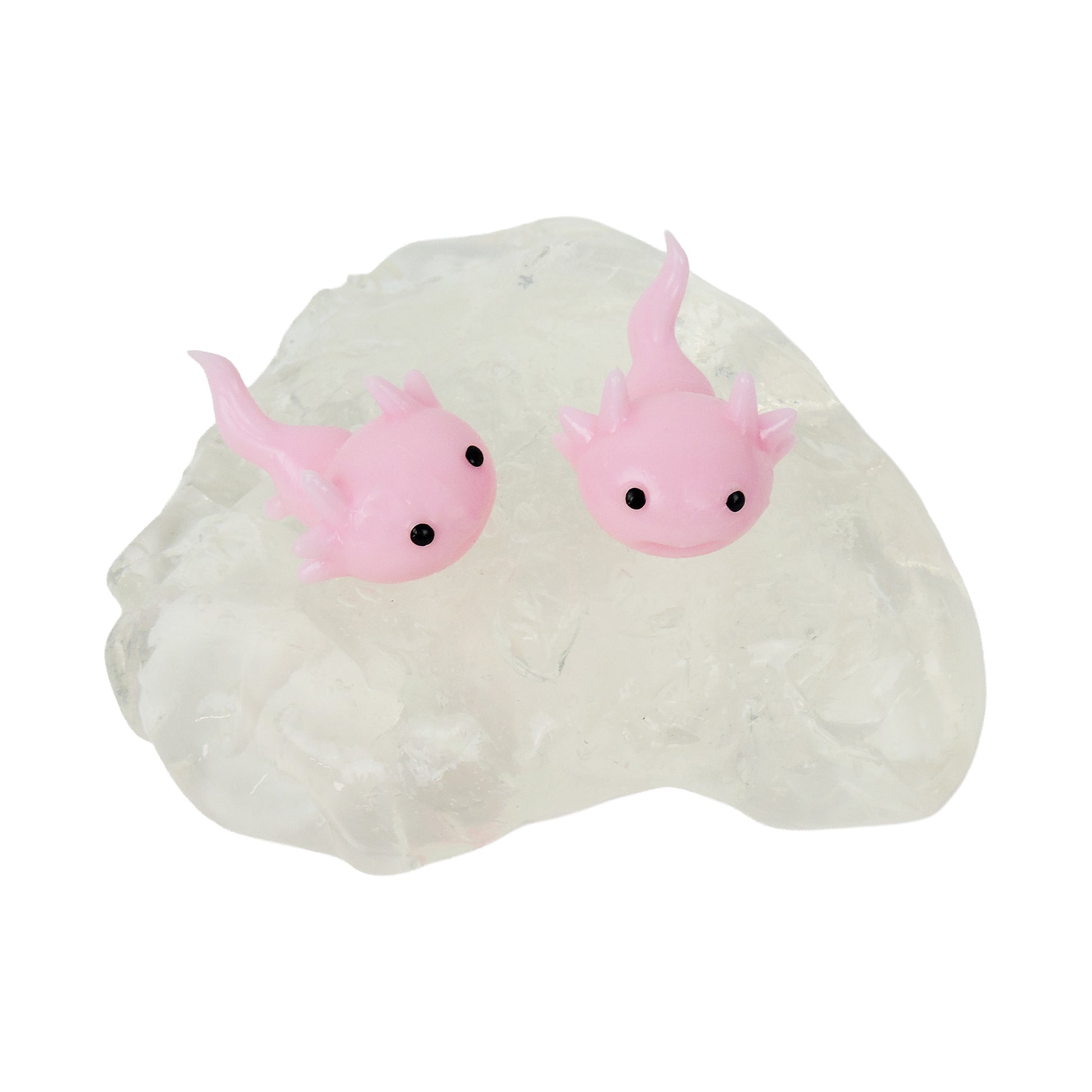 Two Tiny Toys Itty Bitty Axolittles from Tiny Toys, small pink axolotl squishies with black eyes, rest on a clear textured surface that looks like crystal, offering a delightful sensory experience.