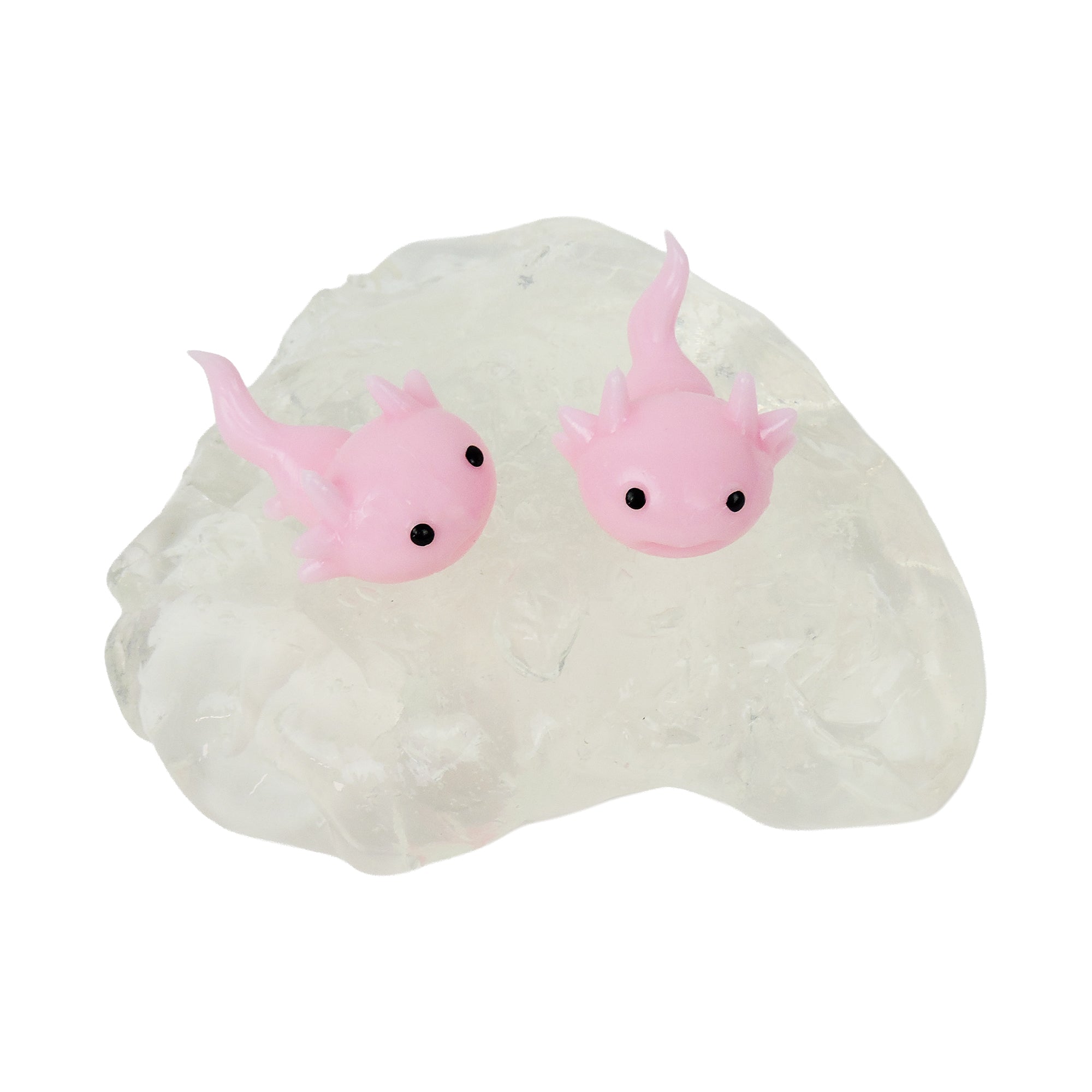 Two Tiny Toys Itty Bitty Axolittles from Tiny Toys, small pink axolotl squishies with black eyes, rest on a clear textured surface that looks like crystal, offering a delightful sensory experience.