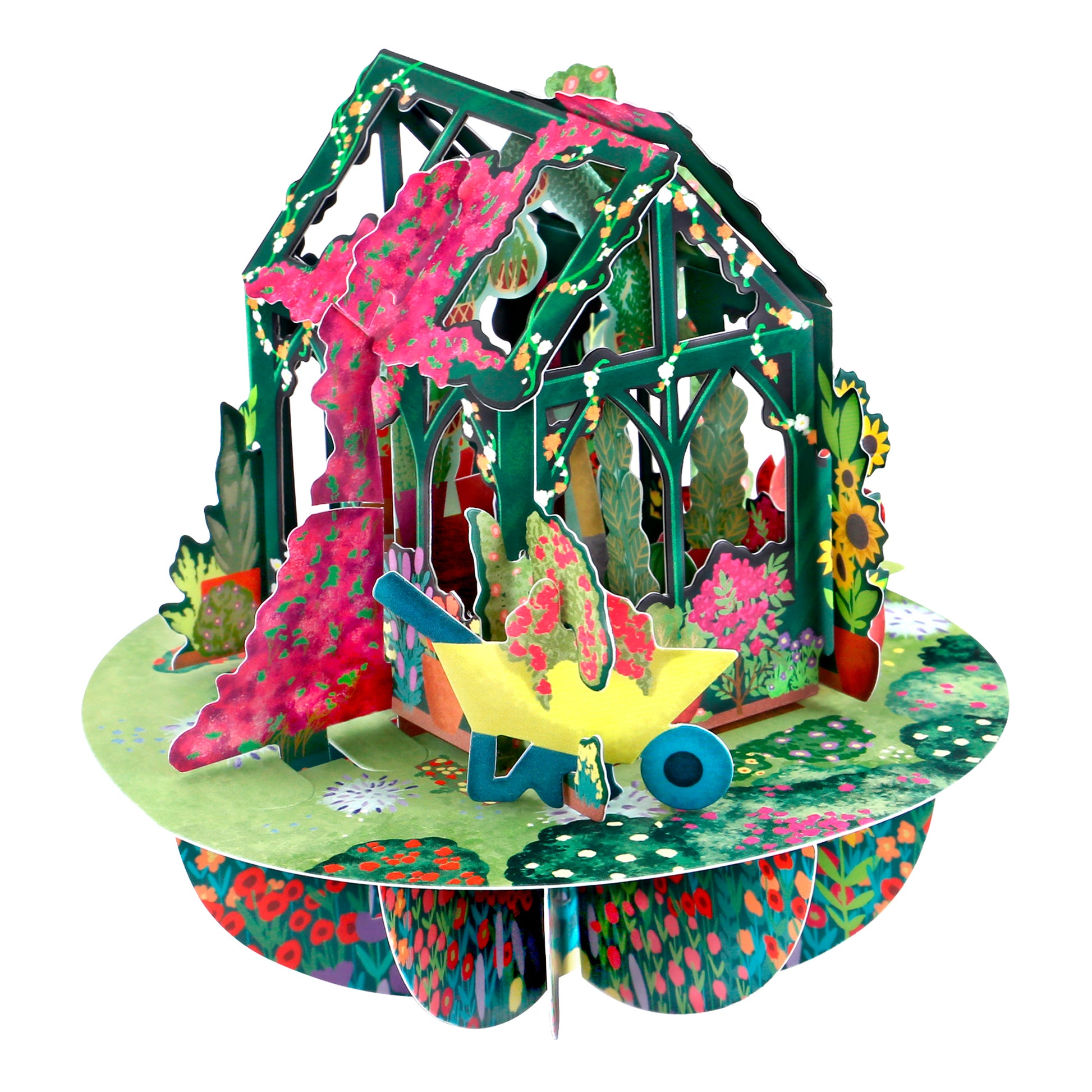 The Santoro Pirouette Card: Secret Garden is a colorful 3D pop-up card showcasing a green greenhouse with pink flowers, a yellow wheelbarrow, and assorted garden plants on a round floral base.