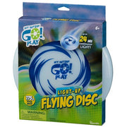 A blue and white box displays the GO! Play GO! Light-Up Flying Disc, featuring swirling graphics and text promoting up to 24 hours of continuous glow. The illuminated disc is visible through the partially open package.