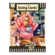 The Santoro Swing Card: Lounging Cats is a 3D pop-up card featuring playful cats around a pink chair, set among plants and furniture, with a colorful, decorative border.