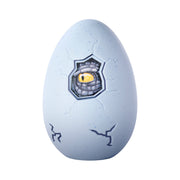 The Simba Dickie Light & Sound Dino Egg Asst features a light gray egg with cracks and an opening showing a yellow reptilian eye, hinting it's about to hatch with exciting light and sound effects.