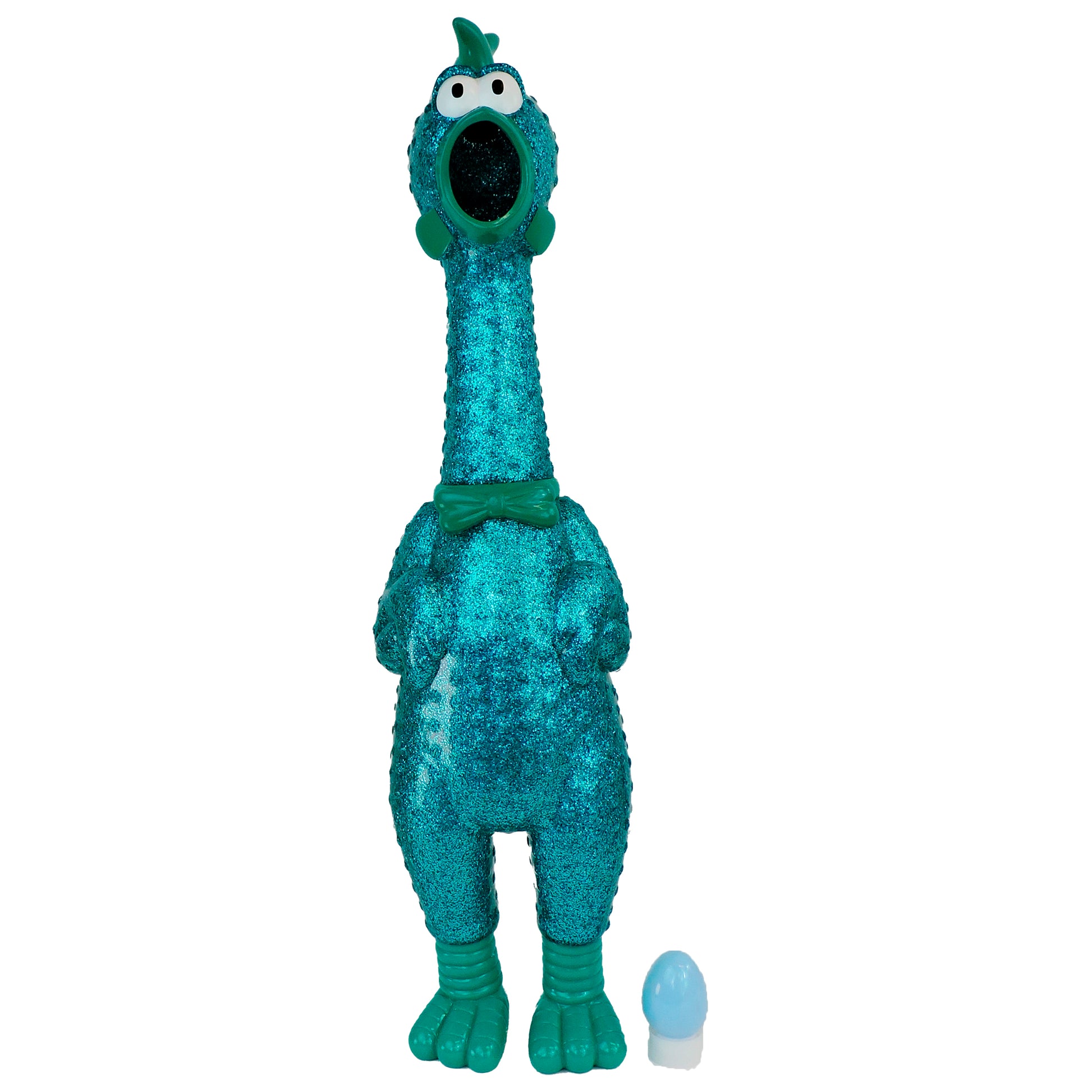 Say Whaaaaat?! The Ampli-Flyer by Say Whaaaaat?! is a turquoise, glittery loud chicken toy with googly eyes, an open beak, and green bow tie, standing upright beside a small blue and white egg.