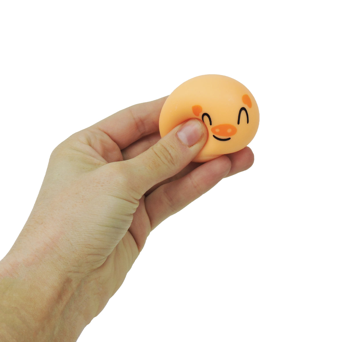A hand squeezes a Toysmith Bao Bun Buddies stress toy with a smiling face and blushing cheeks, set against a white background—ideal for fans of Toysmith fidget toys and cute animal squishies.