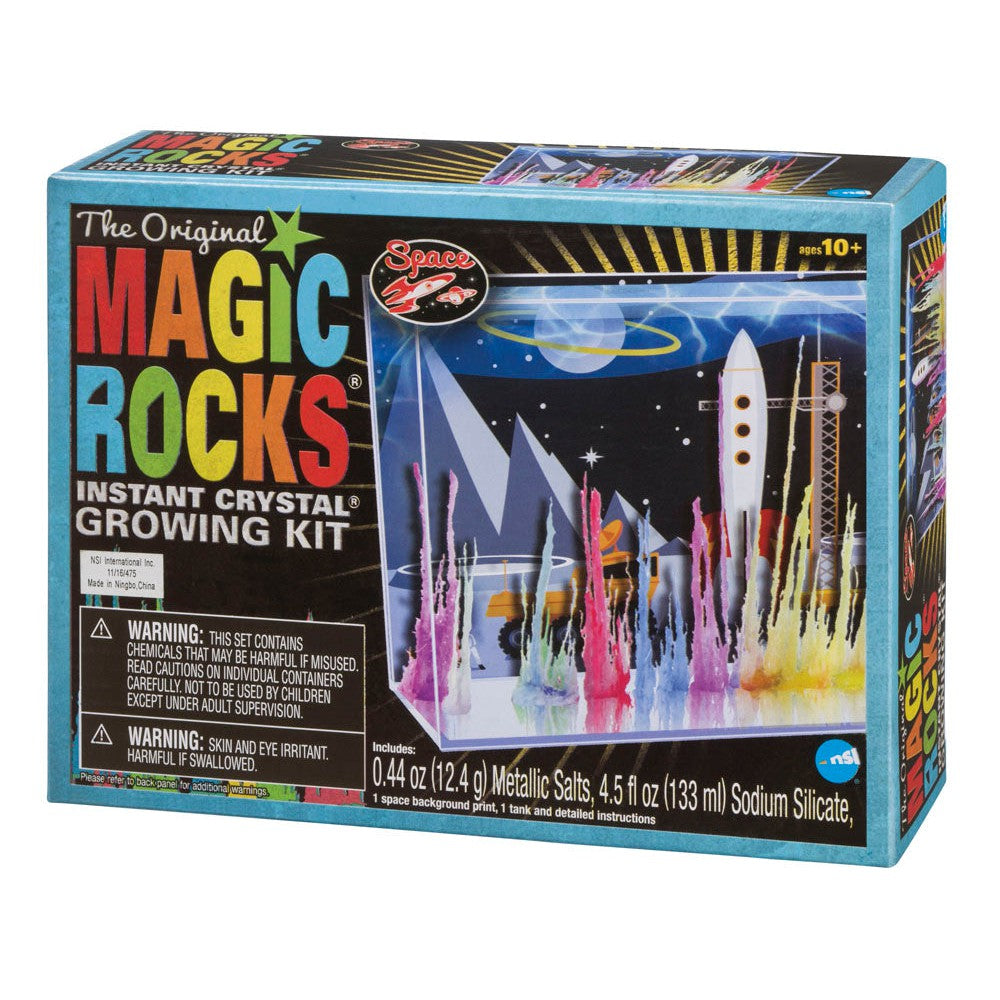 A box of NSI’s The Original Magic Rocks Deluxe Crystal Growing Kit, for ages 10+, features colorful crystals, a white rocket, and planets on the package with included warnings and product details.