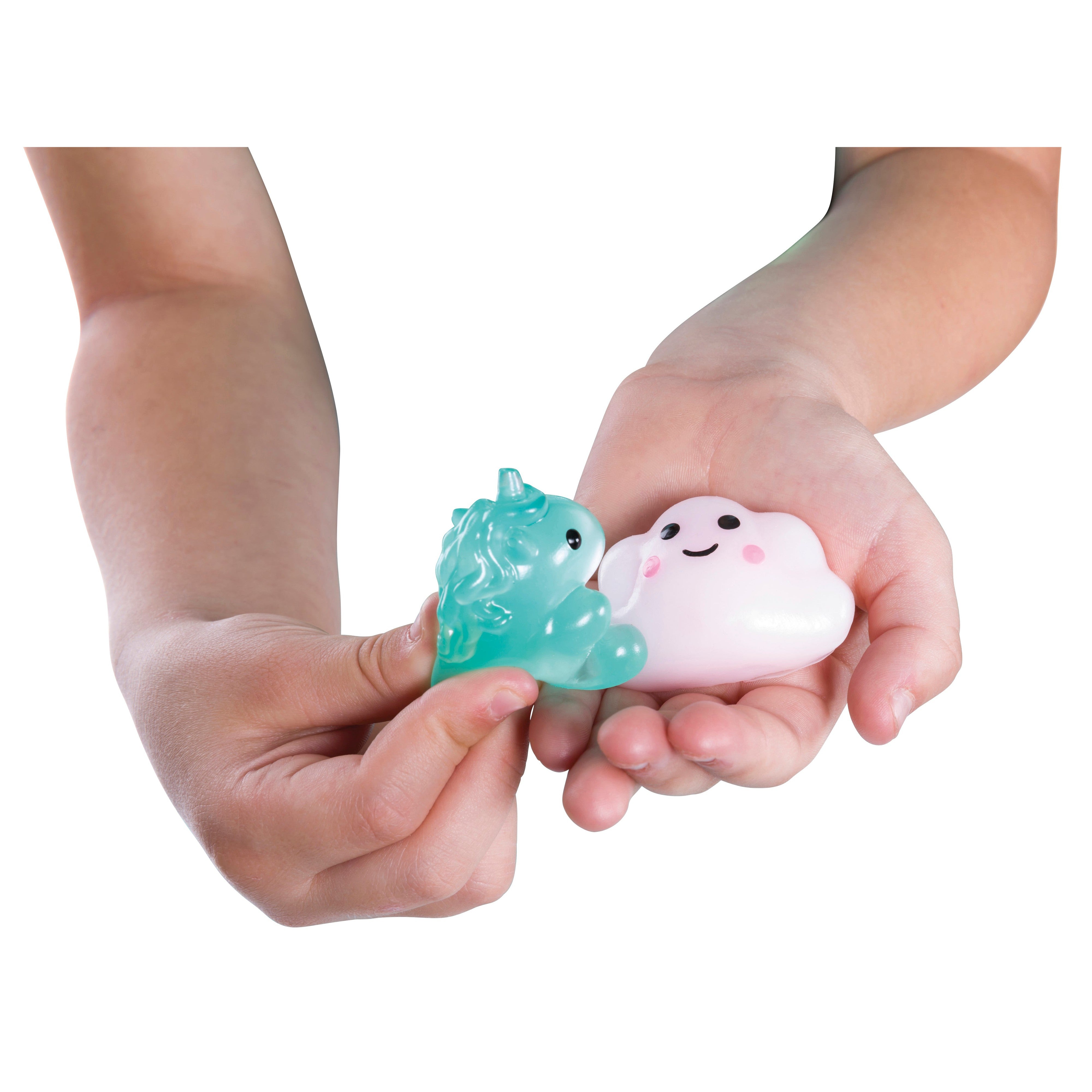 A child’s hands holding two Toysmith Kiji Buddies Unicorns sensory toys: a blue-green unicorn and a white smiling cloud.