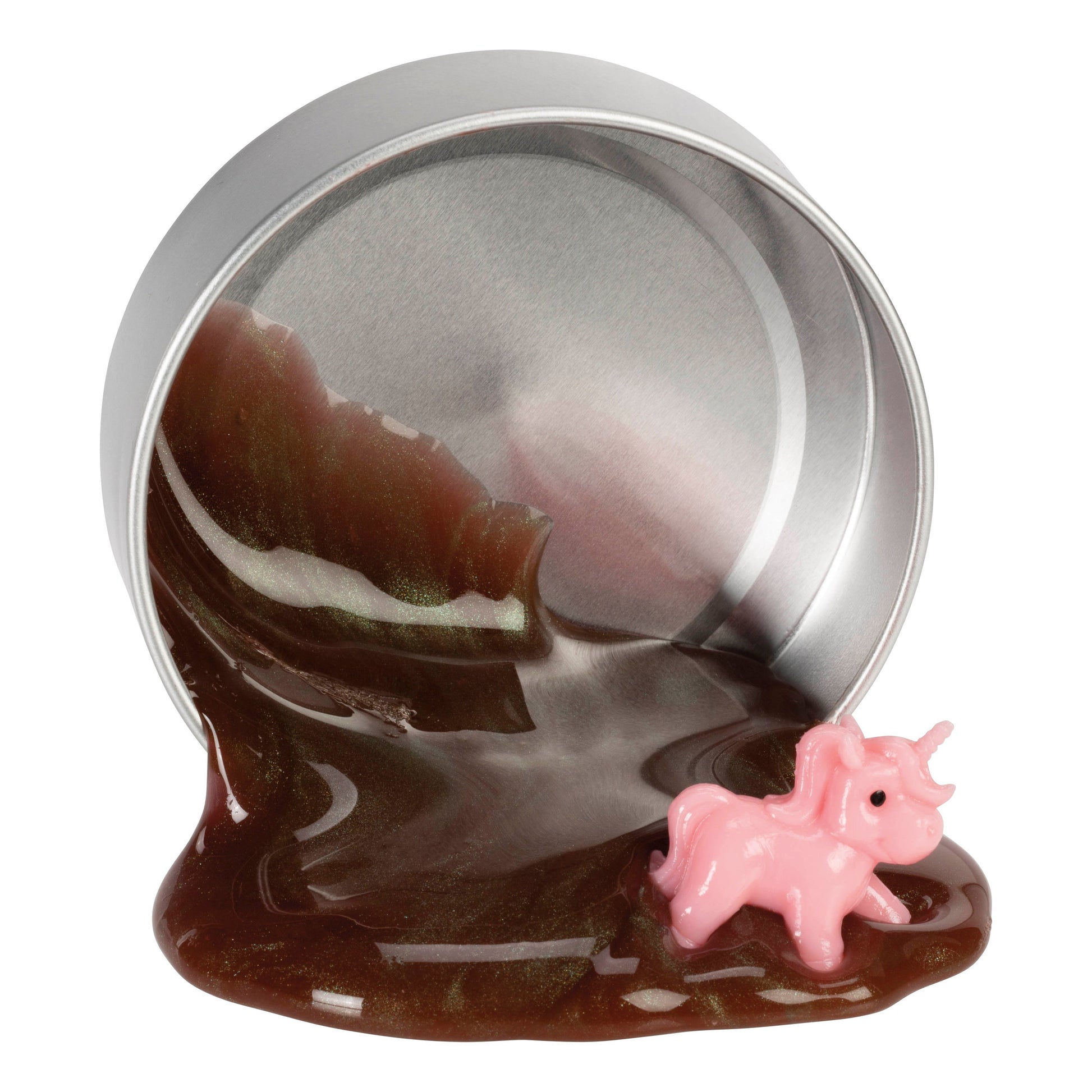 A small Toysmith Bigfoot Scat tin rests on its side, releasing shiny brown putty onto a surface. A tiny pink unicorn figurine is partially embedded in the slime at the tin's opening. Brand: Toysmith.
